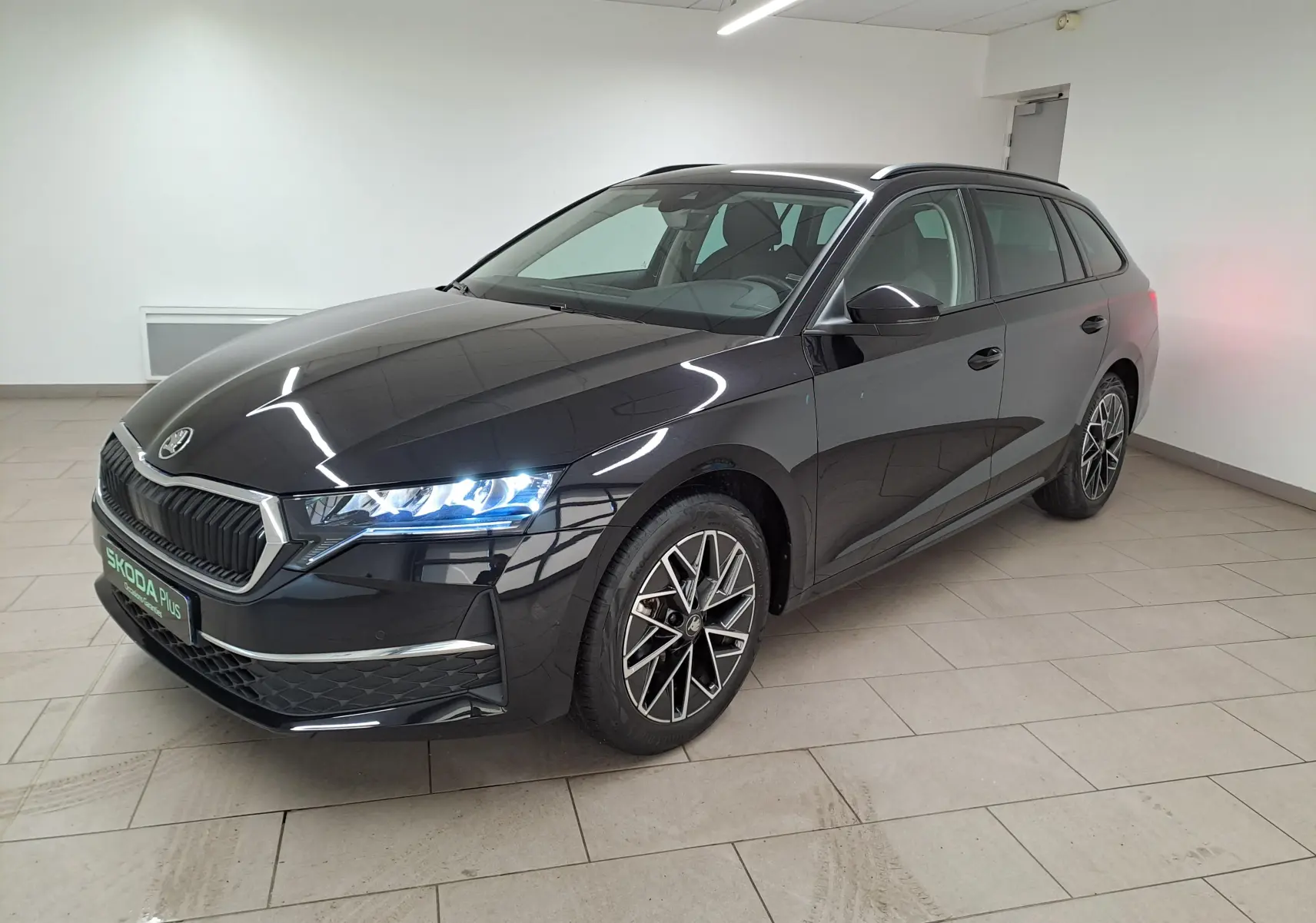 Skoda Octavia Combi 2025 noir Magic nacré en 3/4 avant droit avec jantes alliage 17'' Slagard Aero noires polies.