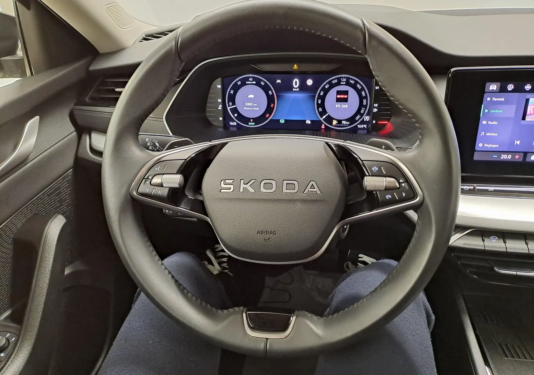 Vue intérieure centrée sur le volant SKODA et le tableau de bord numérique d'une Octavia Combi 2025.