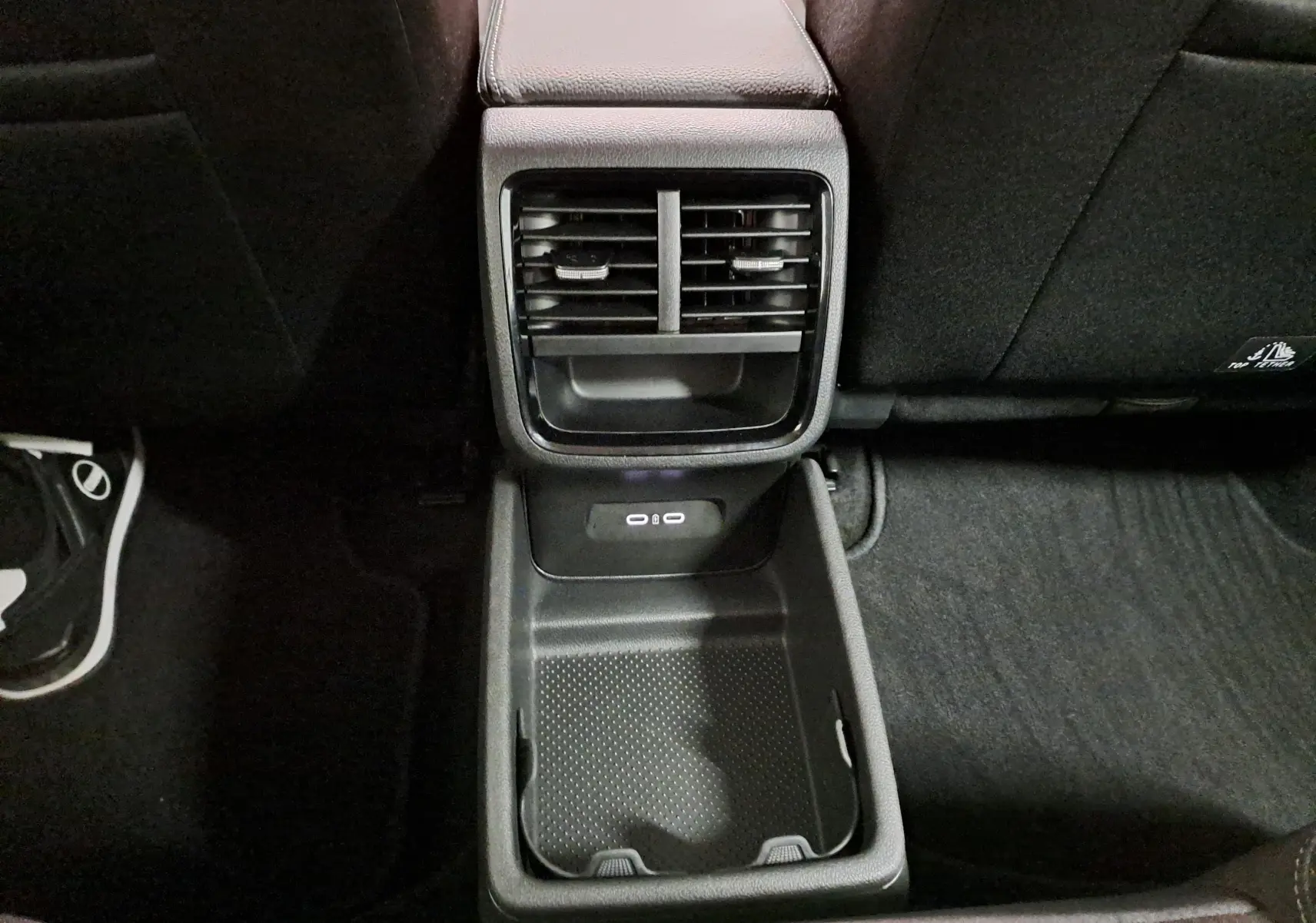 Vue rapprochée de la console arrière noire avec bouches d’aération et prises USB dans une Skoda Octavia Combi 2025.
