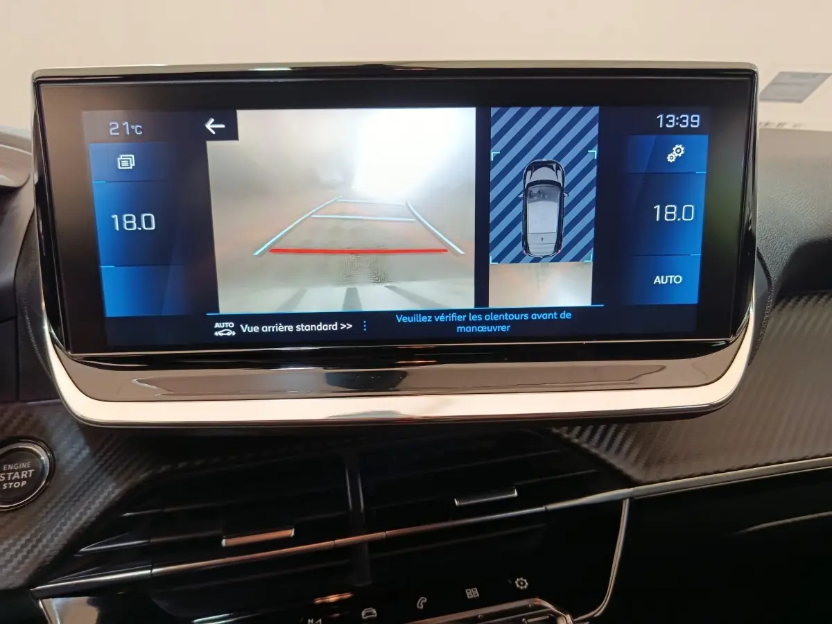 Écran tactile central de la Peugeot 208 BlueHDi 100 montrant la caméra de recul et l’aide au stationnement arrière.