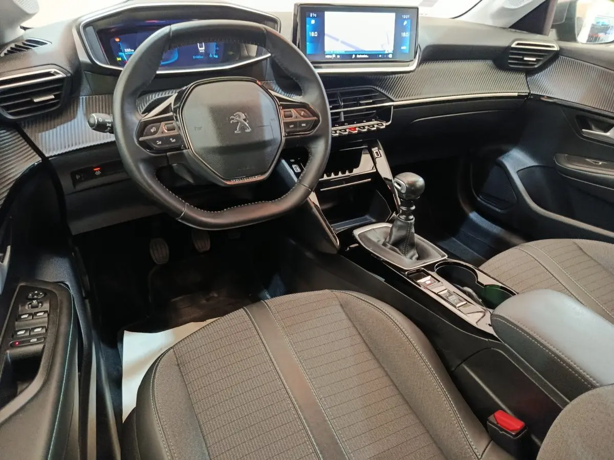 Vue intérieure avant droite de la Peugeot 208 2020, volant cuir multifonctions et écran tactile 10 pouces.
