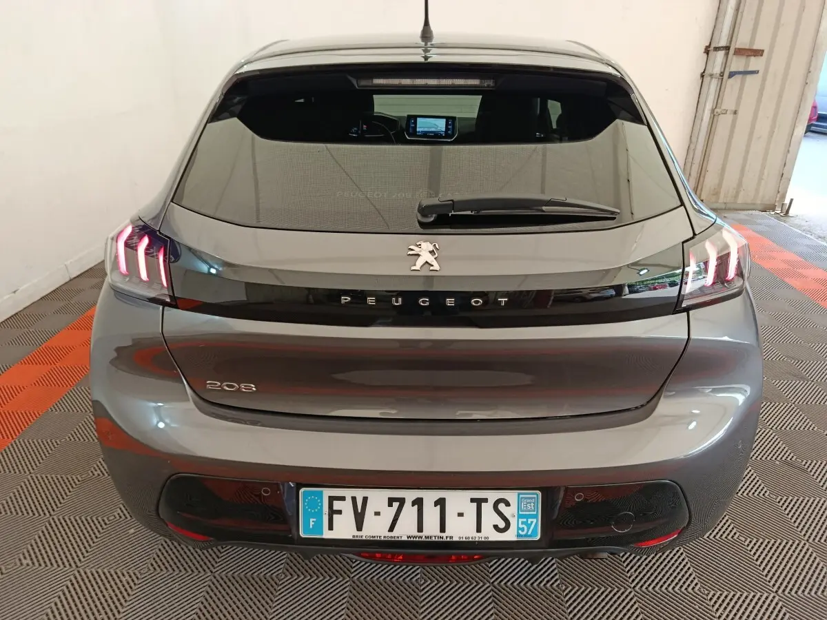 Vue arrière d’une Peugeot 208 gris foncé avec feux LED caractéristiques et plaque d’immatriculation française visible.
