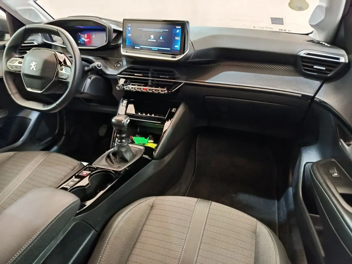 Intérieur de la Peugeot 208 BlueHDi 100 S&S Allure Business 2020, vue côté passager avec tableau de bord et volant cuir noir.