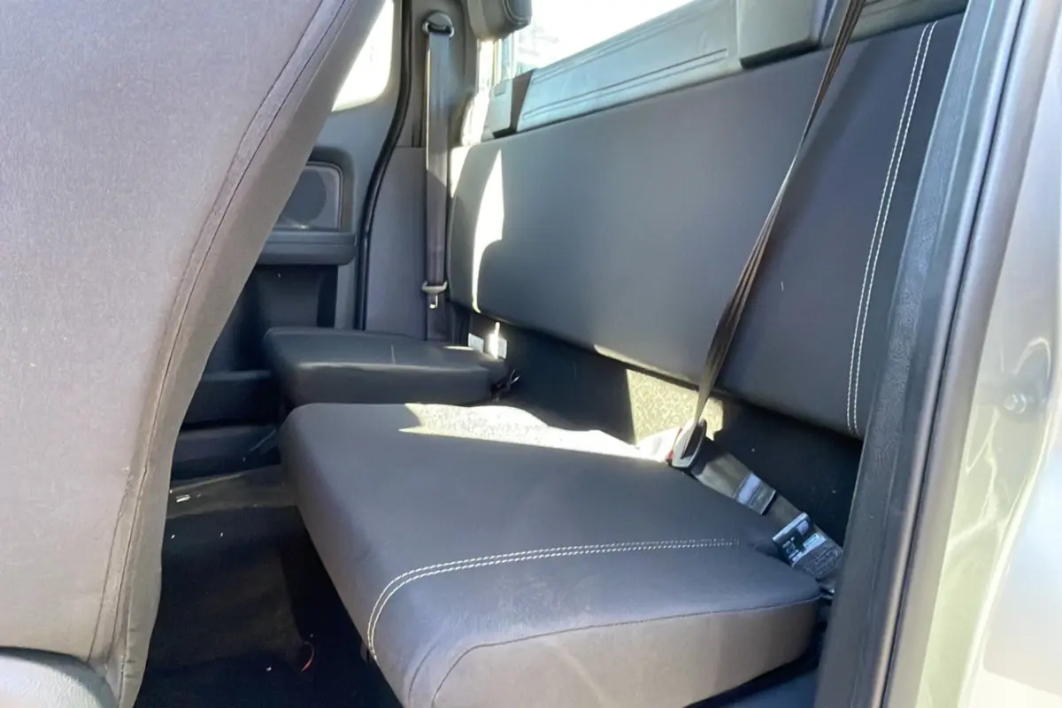 Vue intérieure arrière côté droit du Ford Ranger gris iconic, montrant la banquette en cuir noir avec surpiqûres blanches et ceintures de sécurité.