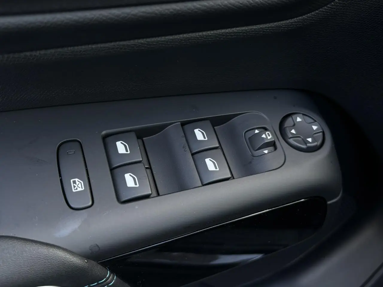 Gros plan sur les commandes de lève-vitres et réglages des rétroviseurs côté gauche d'un Citroën C5 Aircross Bleu Eclipse.