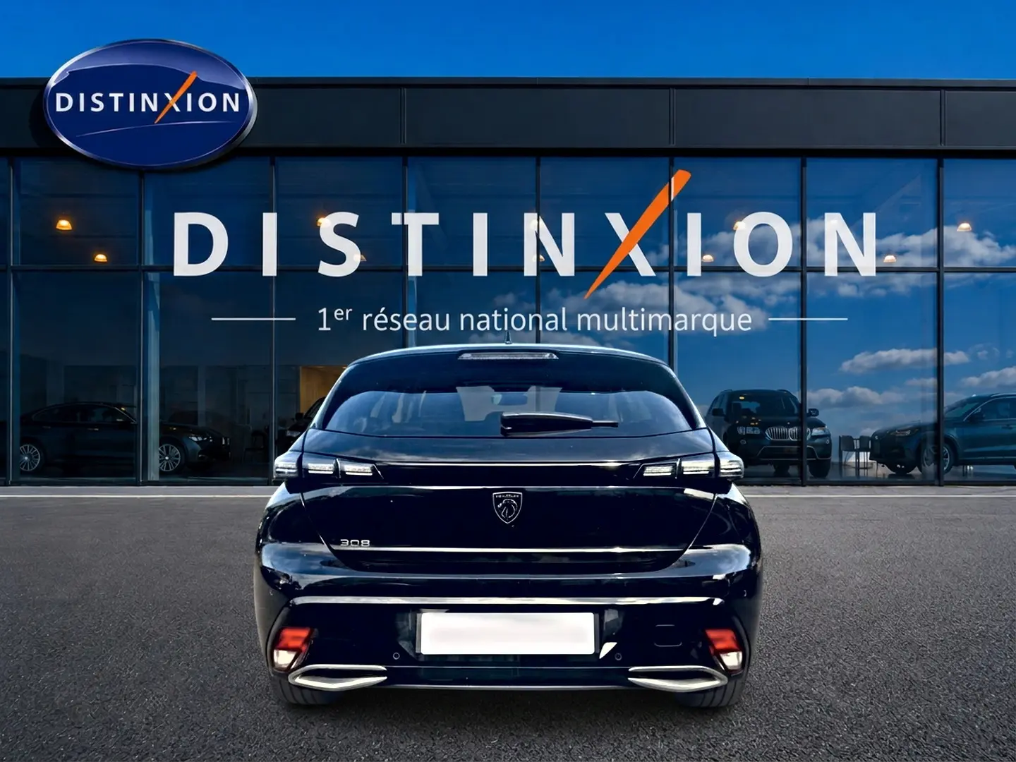 Vue arrière d'une Peugeot 308 noire 2025 garée devant une vitrine avec logo Distinxion visible en arrière-plan.