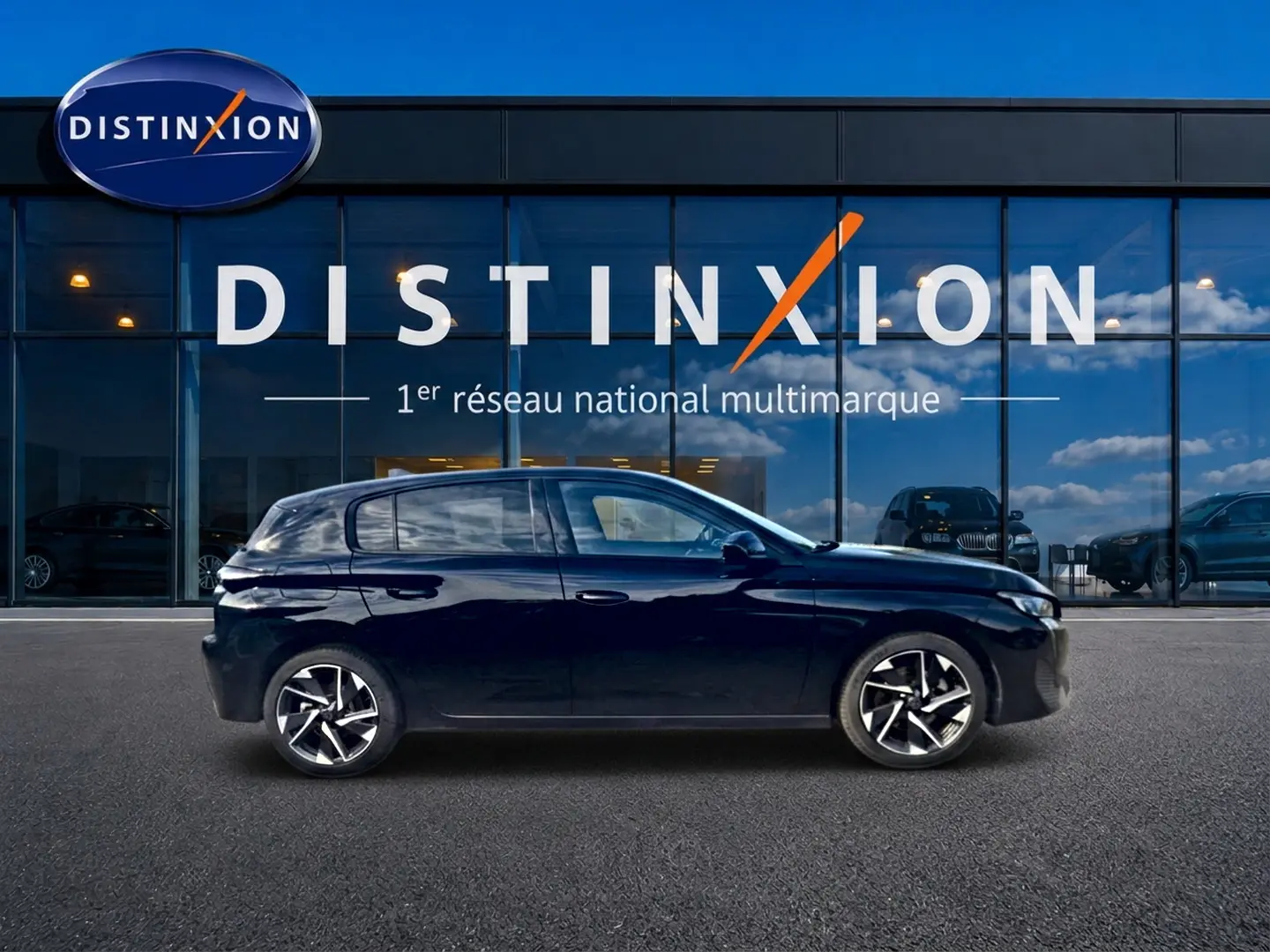 Profil droit d'une Peugeot 308 noire 2025 garée devant une vitrine avec logo Distinxion.