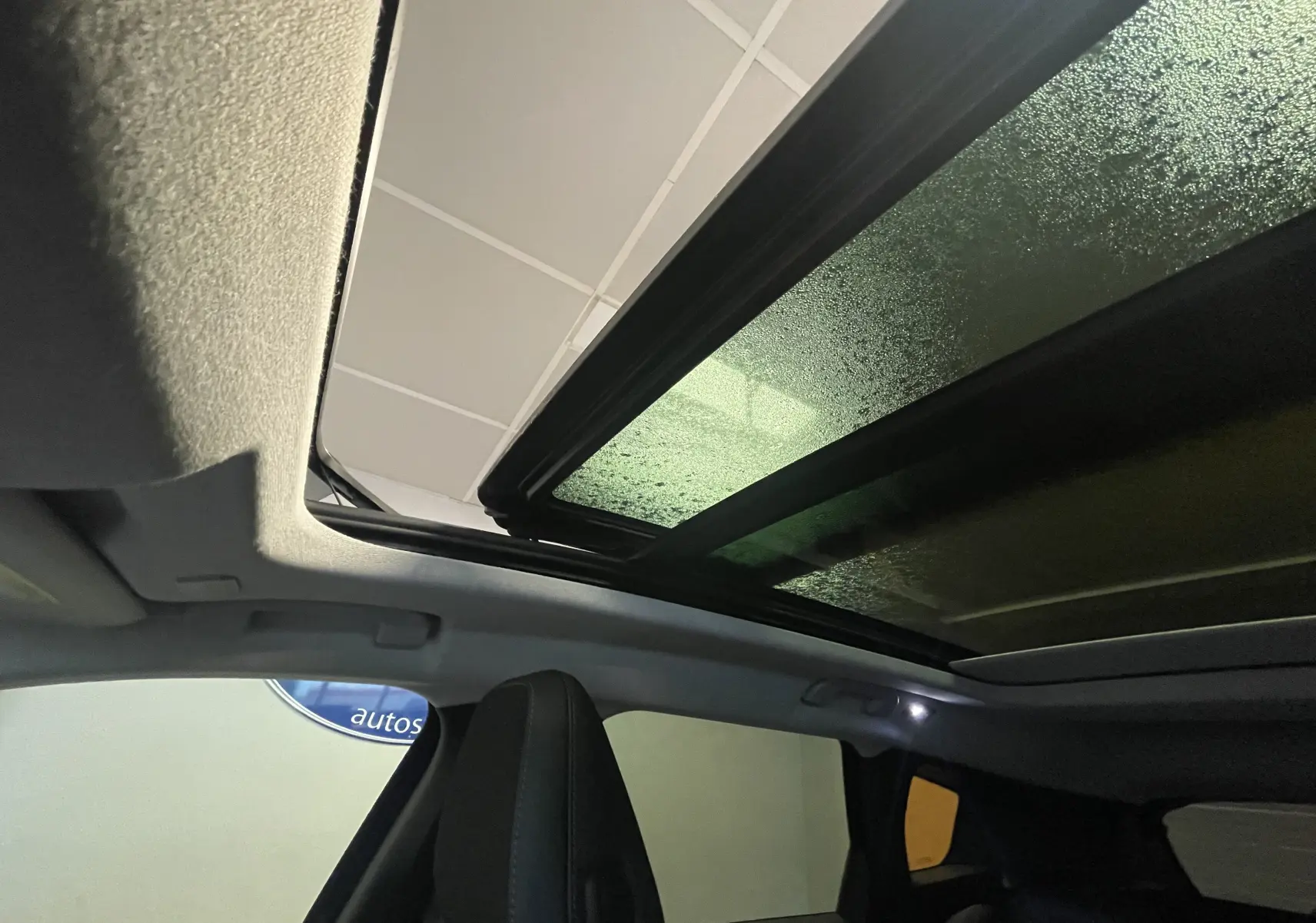 Gros plan sur la console centrale du Citroën C5 Aircross hybride 2026, montrant prises USB, prise 12V et porte-gobelets beige.