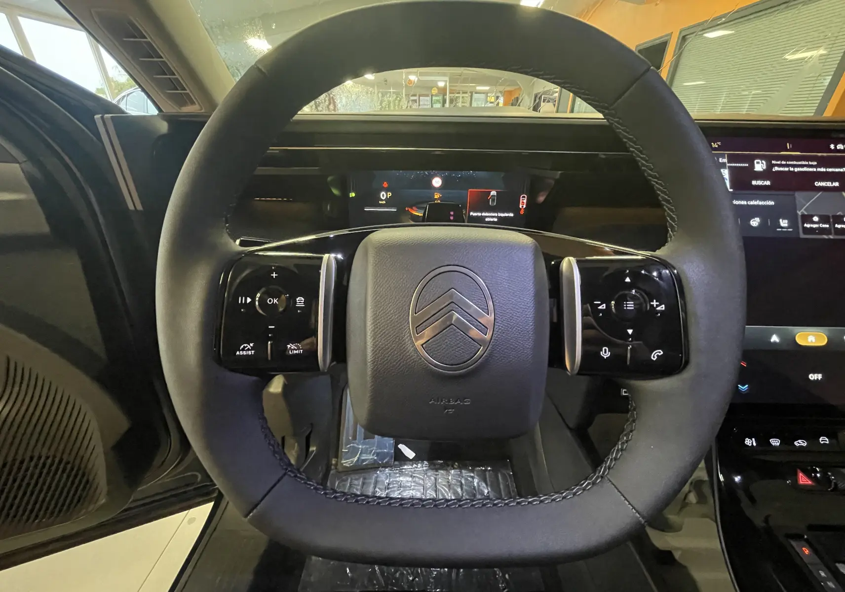Vue intérieure côté conducteur du Citroën C5 Aircross hybride 2026 avec sièges noirs et console centrale moderne.