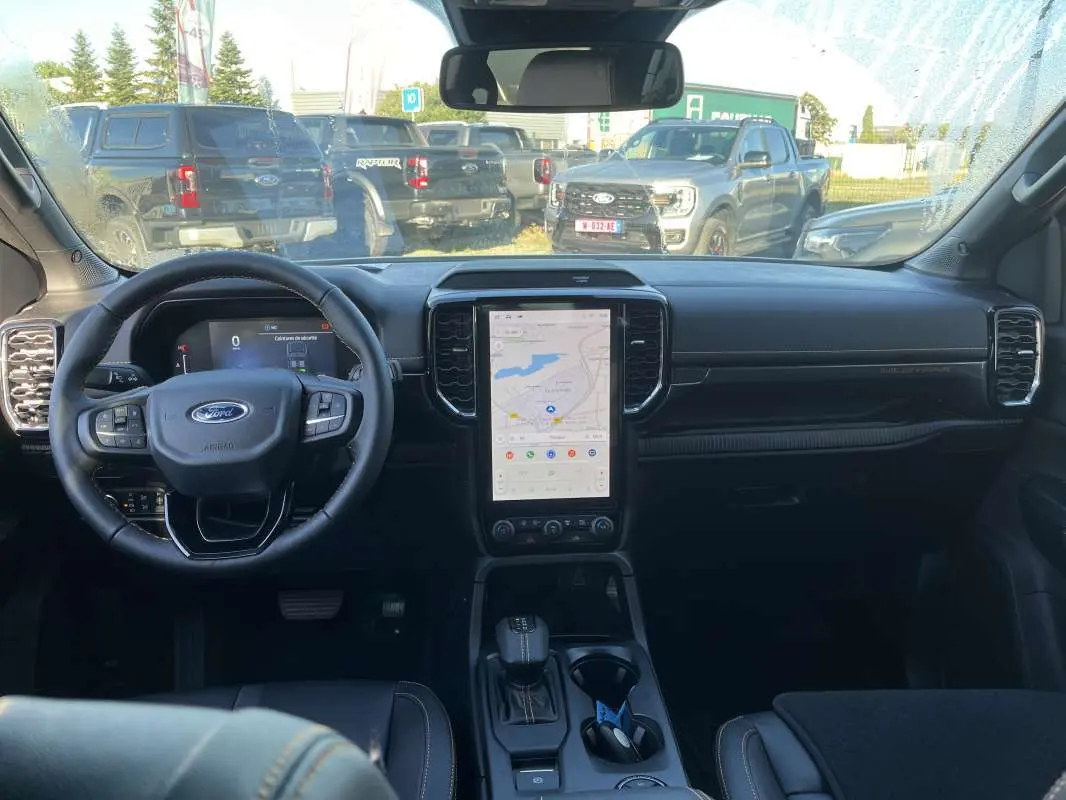 Vue intérieure frontale du Ford Ranger 2026 avec tableau de bord noir et écran tactile vertical central allumé.