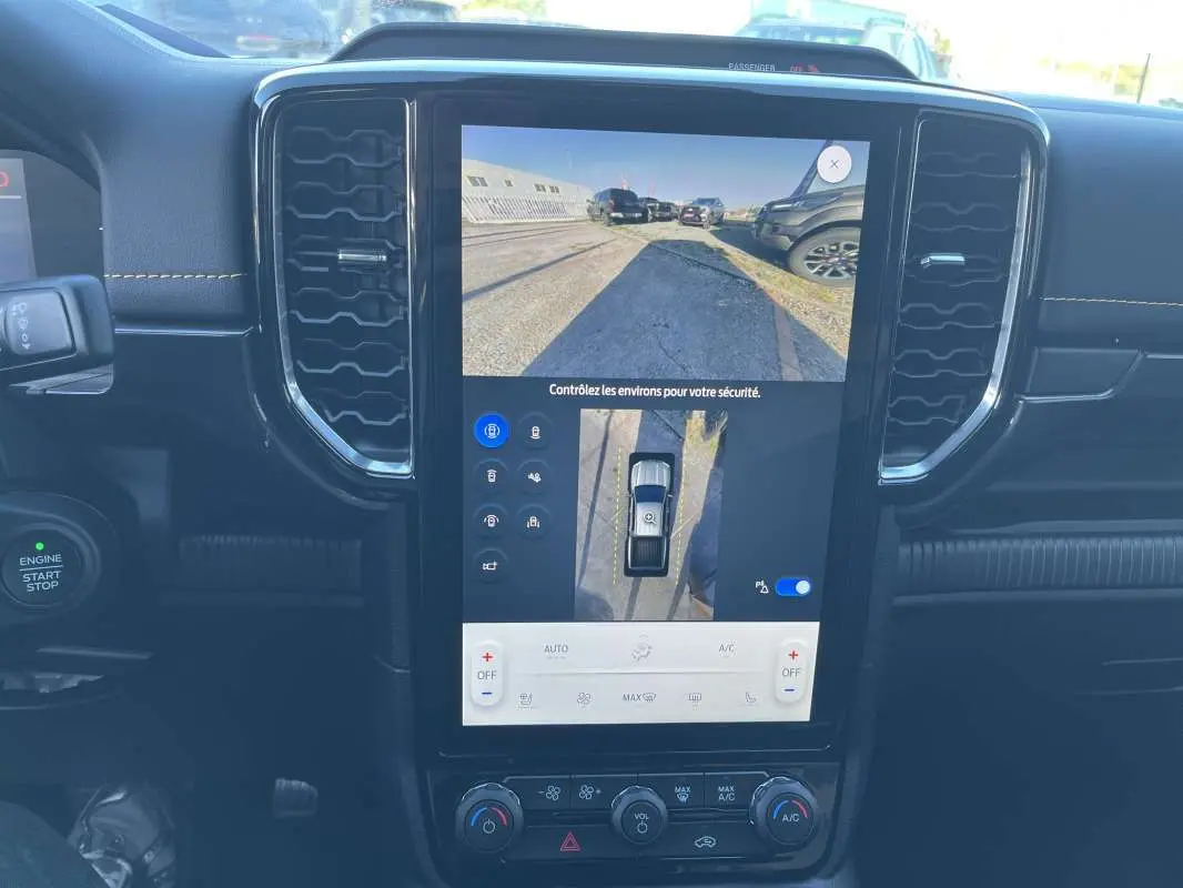 Vue intérieure centrée sur l'écran tactile du Ford Ranger blanc glacier 2026 avec caméra 360° et commandes climatisation.