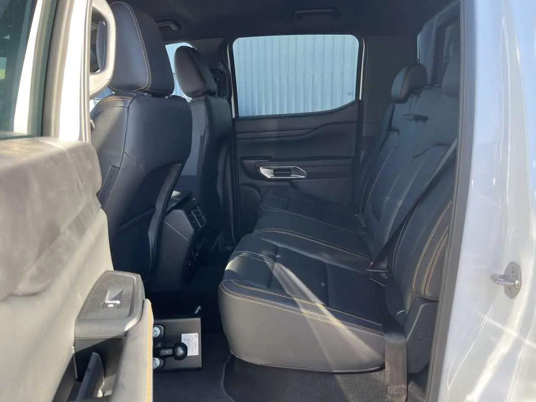 Vue latérale droite de l’intérieur arrière du Ford Ranger blanc glacier, sièges en cuir noir avec surpiqûres contrastantes.
