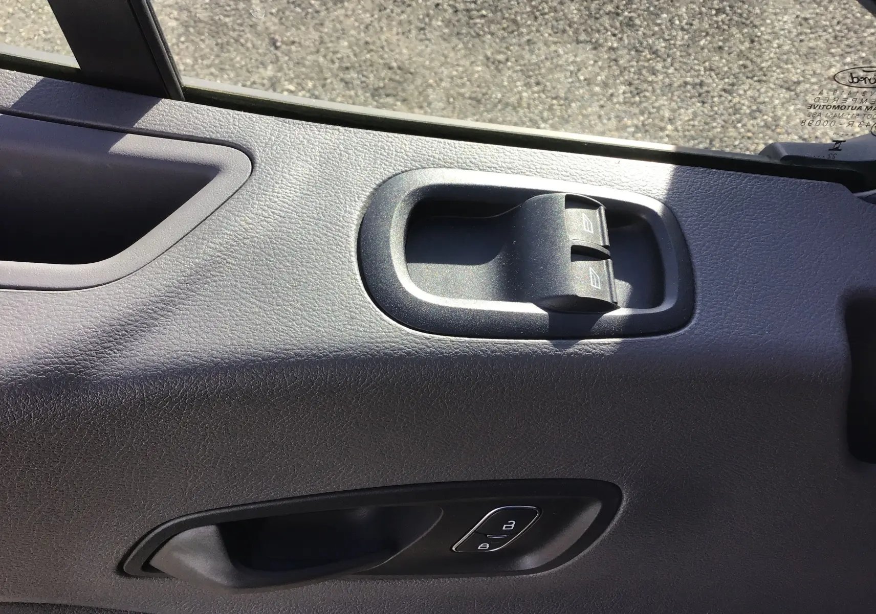 Gros plan sur la commande des vitres et la poignée intérieure côté conducteur du Ford Transit Chassis Cabine blanc.