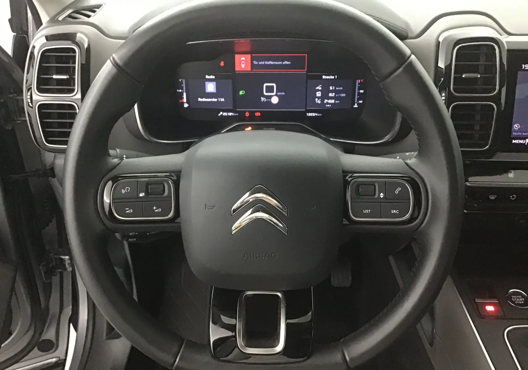 Vue rapprochée du volant cuir noir et du tableau de bord numérique du Citroën C5 Aircross gris Artense 2021.