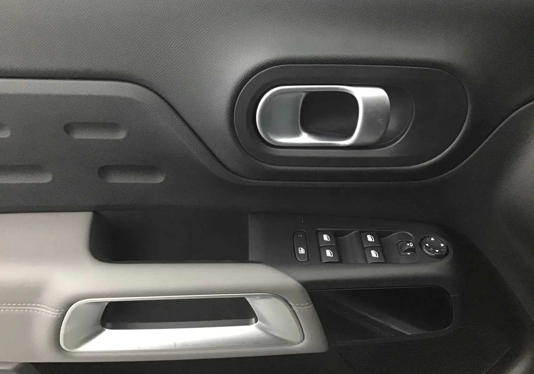 Poignée intérieure et commandes des vitres côté gauche d'une Citroën C5 Aircross gris Artense, finition Feel Pack 2021.