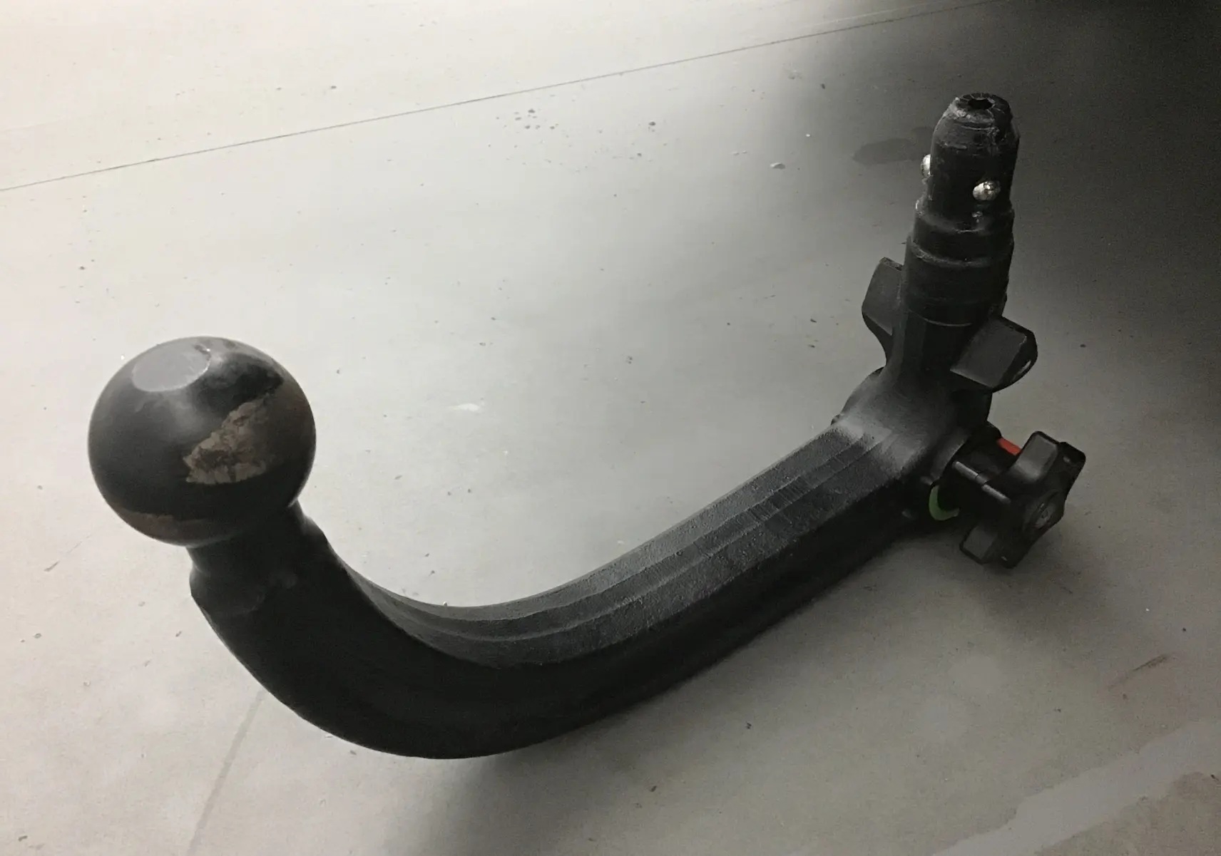 Gros plan sur une boule d'attelage noire amovible pour Citroën C5 Aircross gris Artense, posée sur sol clair.