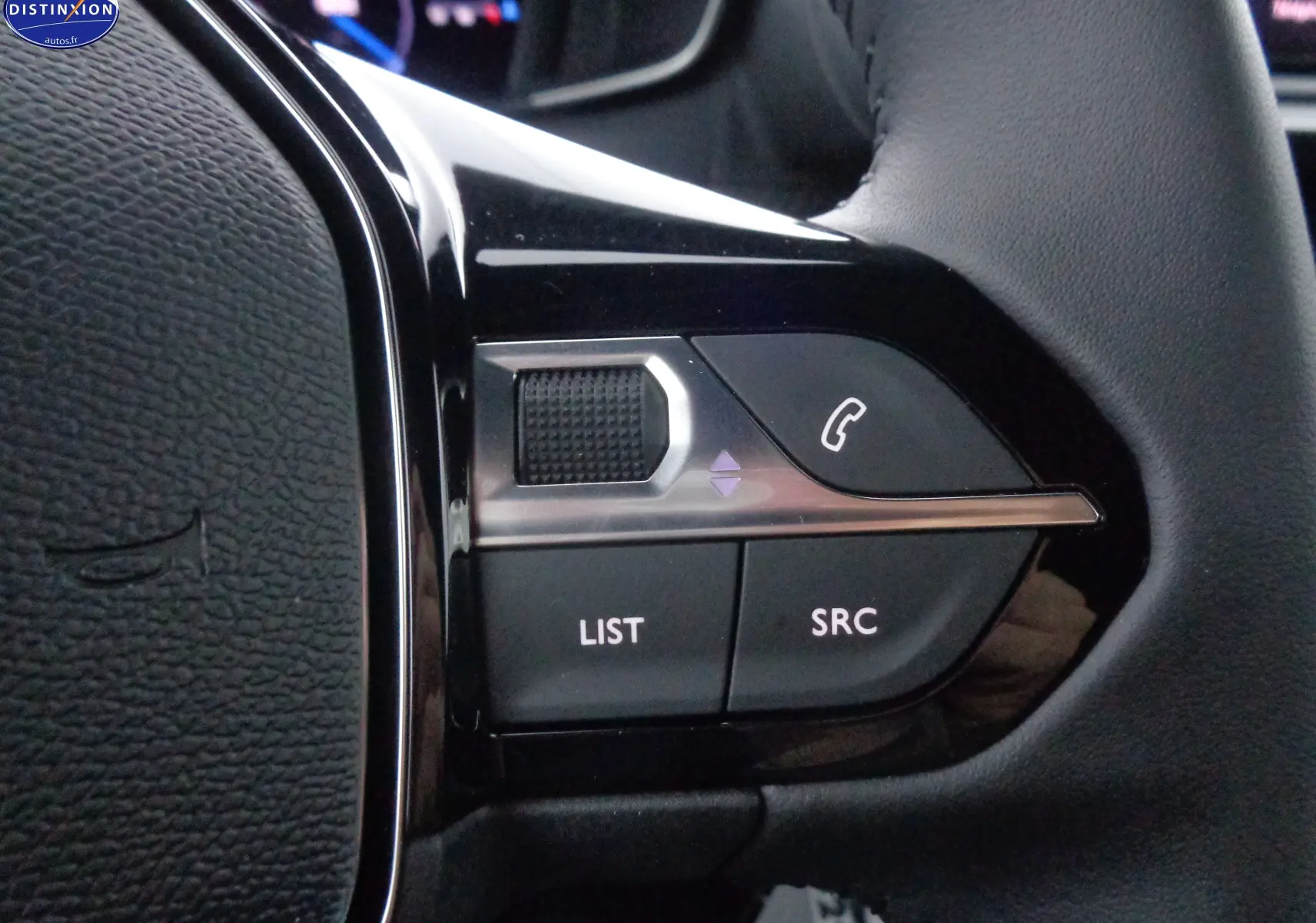 Gros plan sur les commandes gauche du volant du Peugeot 2008 bleu Vertigo Metal, boutons LIST, SRC et téléphone.