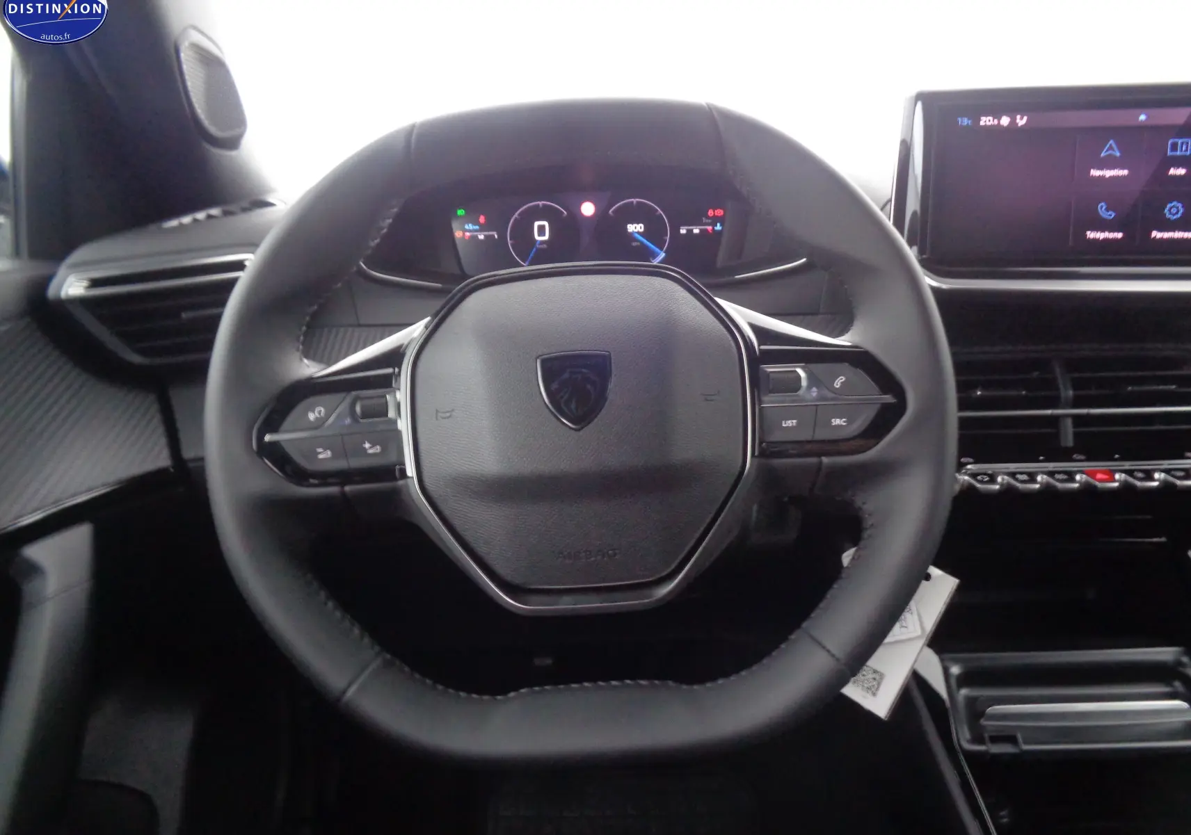 Vue rapprochée du volant noir du Peugeot 2008 2023 avec tableau de bord numérique et écran tactile central.