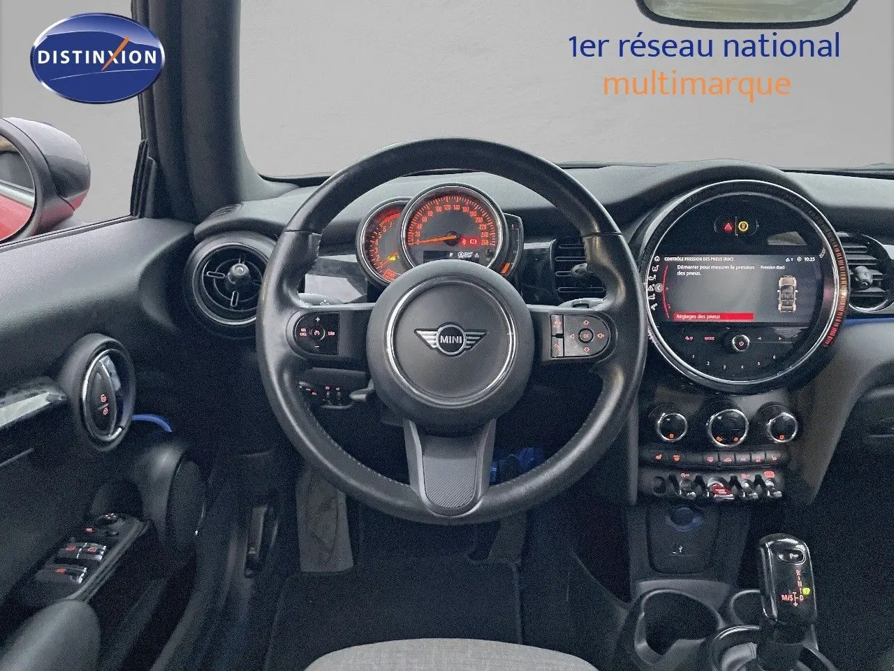 Vue intérieure centrée sur le volant et le tableau de bord numérique de la MINI Cabriolet rouge Chili 2023.
