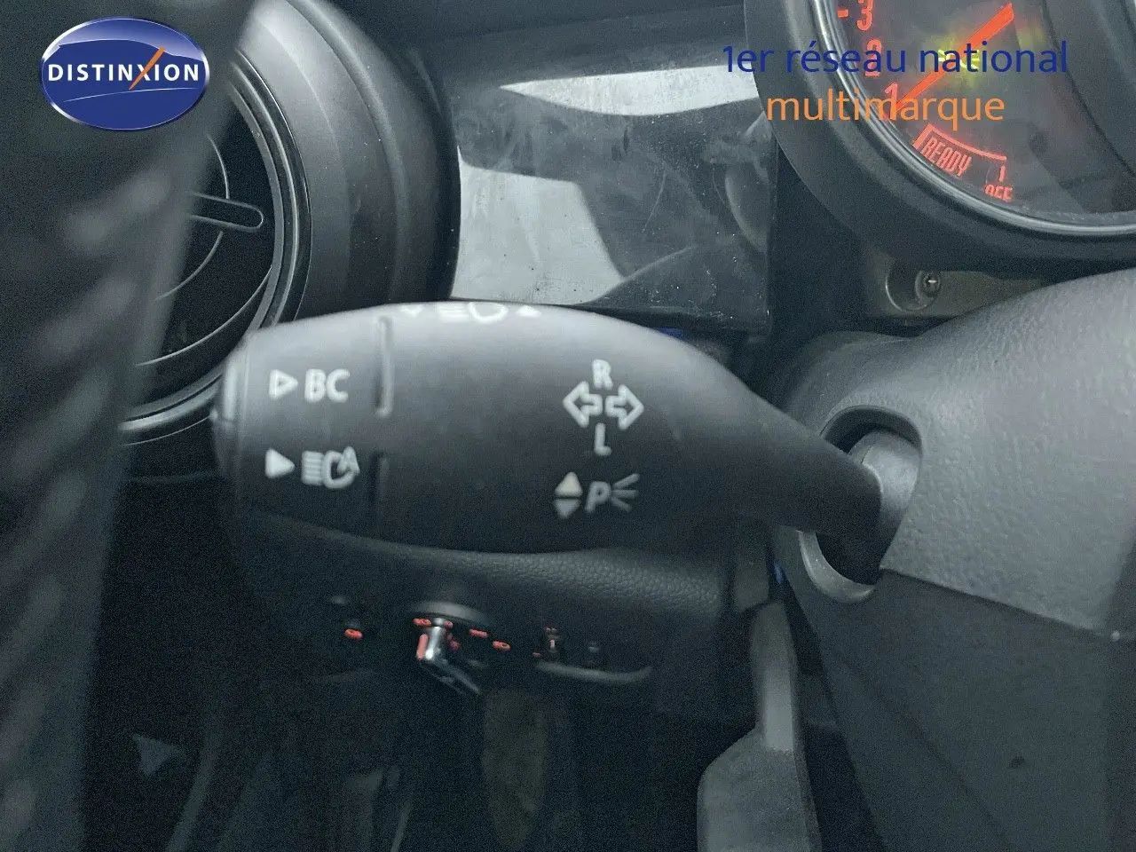 Gros plan sur la commande de clignotant à gauche du volant dans l'habitacle d'une MINI Cabriolet rouge Chili 2023.