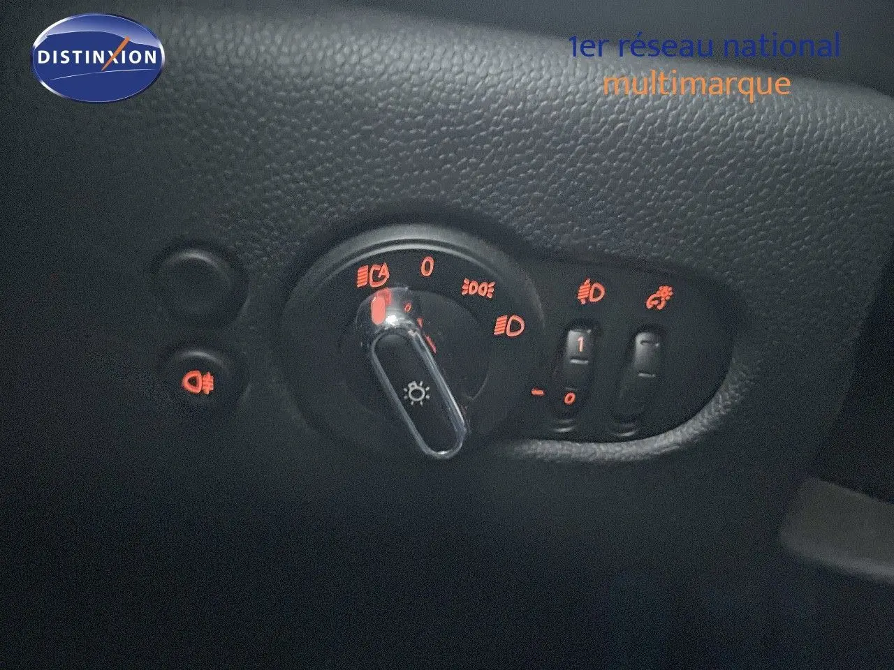 Gros plan sur la commande d’éclairage intérieure de la MINI Cabriolet F57 rouge chili, avec voyants lumineux orange allumés.