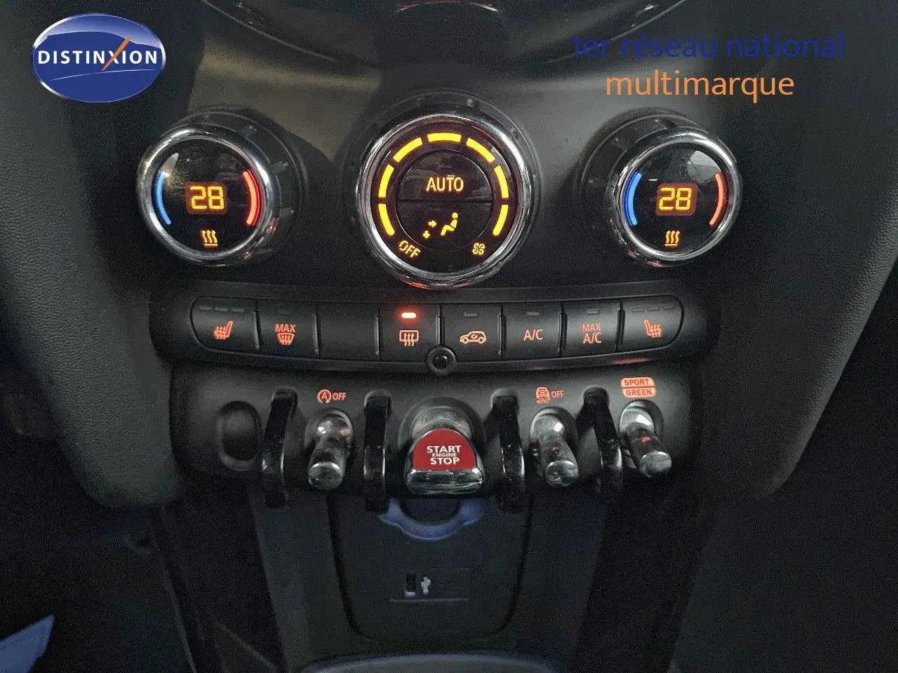 Gros plan sur la console centrale du MINI Cabriolet rouge Chili 2023, montrant les commandes de climatisation et le bouton start/stop.