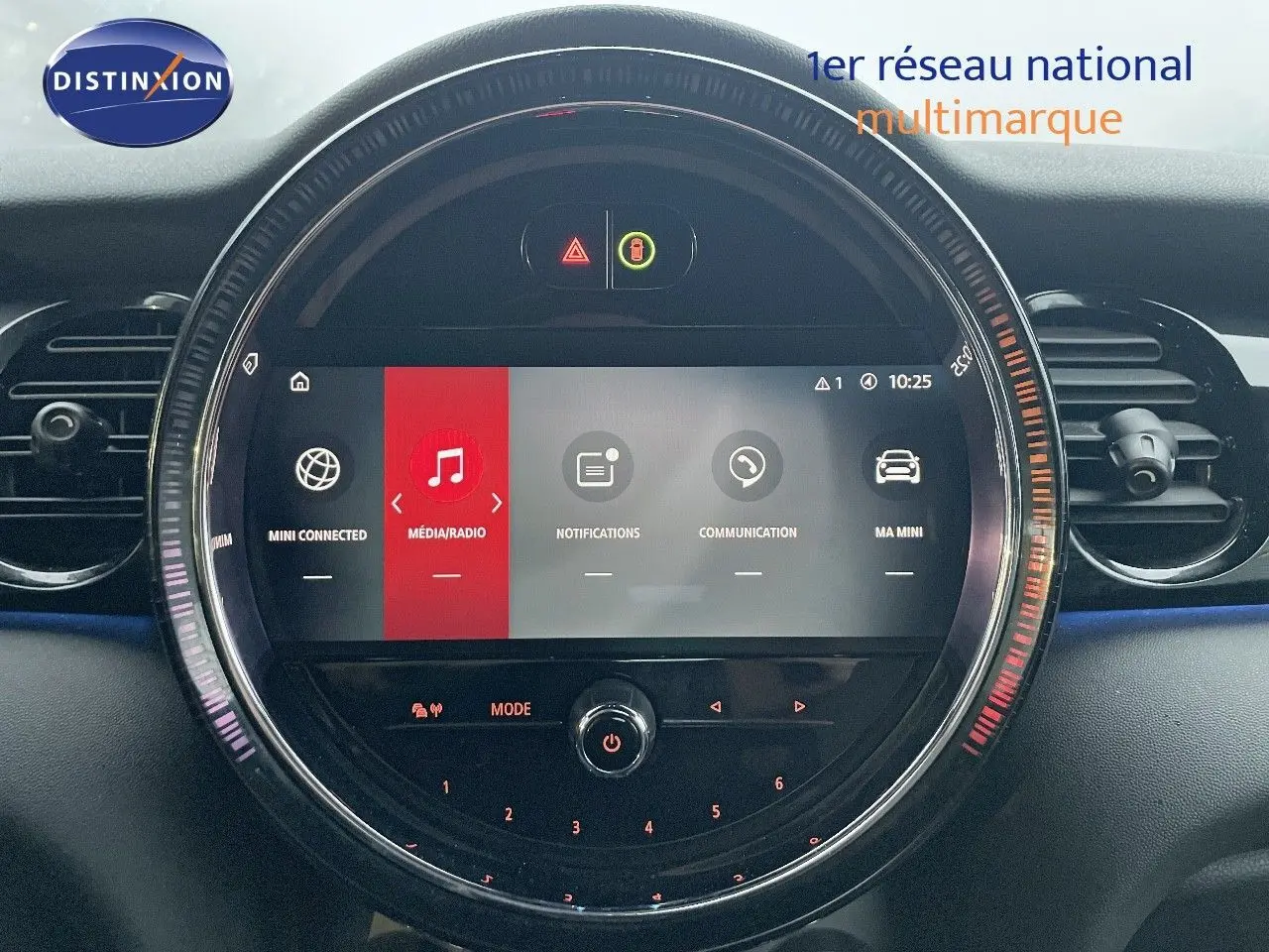 Gros plan sur l’écran central rond du tableau de bord de la MINI Cabriolet F57 rouge chili, affichant le menu multimédia.