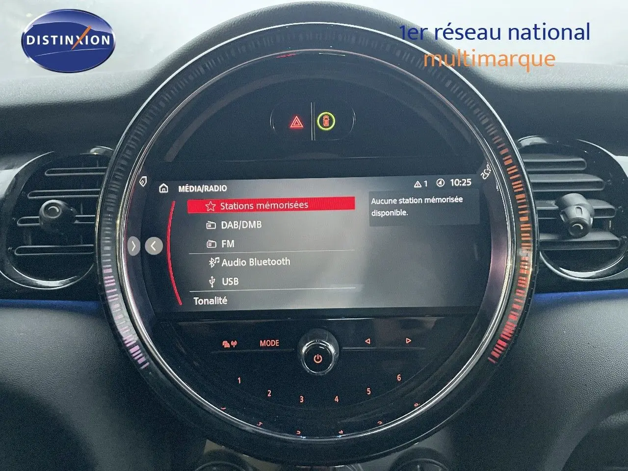 Tableau de bord de MINI Cabriolet F57 rouge chili, vue centrée sur l’écran multimédia circulaire avec options radio affichées.