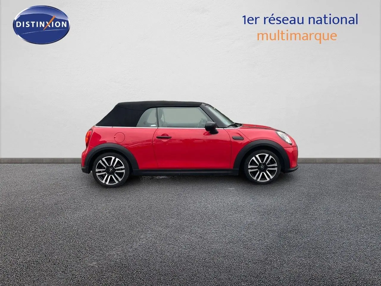 Profil gauche d'une MINI Cabriolet F57 rouge chili avec toit noir fermé et jantes bi-ton.