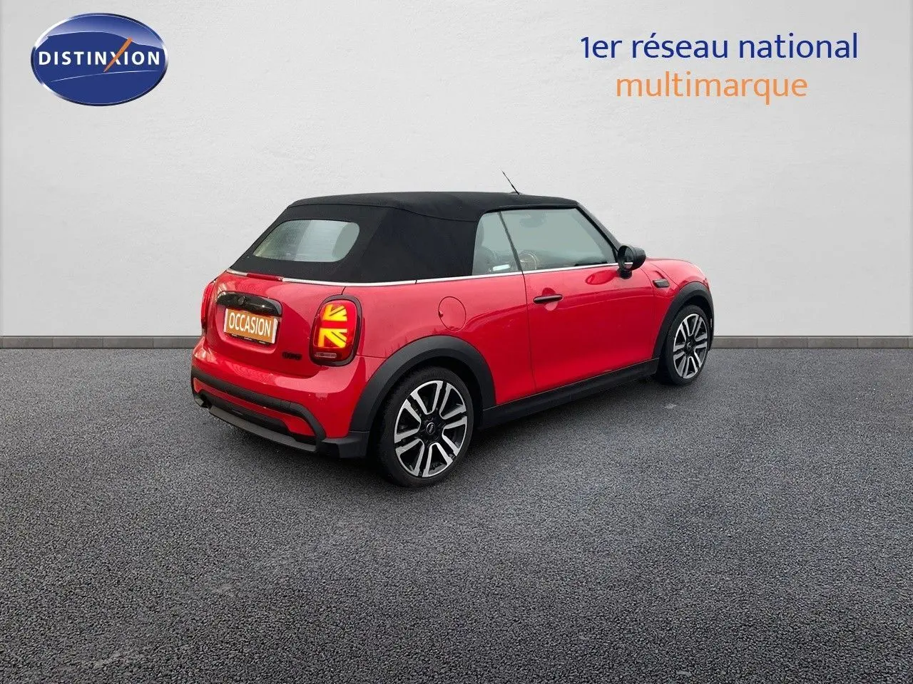 Vue 3/4 arrière droite d'une MINI Cabriolet F57 rouge chili avec toit noir et feux arrière à motif Union Jack.