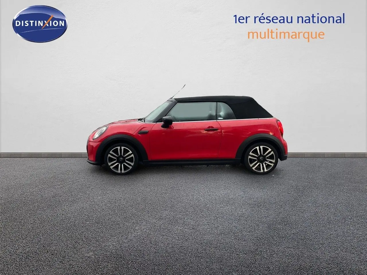 Profil droit d'une MINI Cabriolet F57 rouge chili avec toit noir relevé, roues alliage 17 pouces bi-ton visibles.