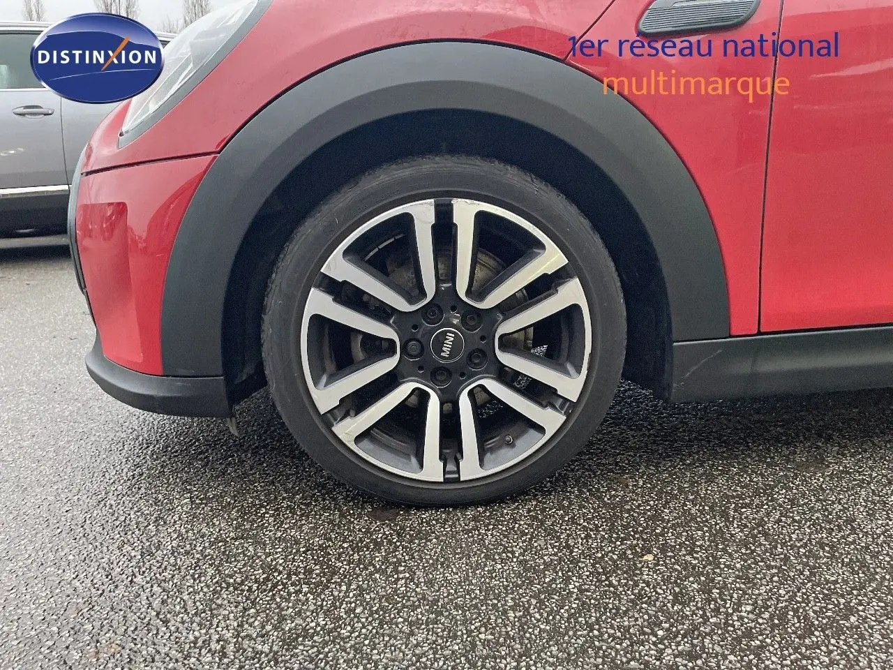 Gros plan sur la roue avant gauche d'une MINI Cabriolet F57 rouge chili avec jante alu bi-ton.