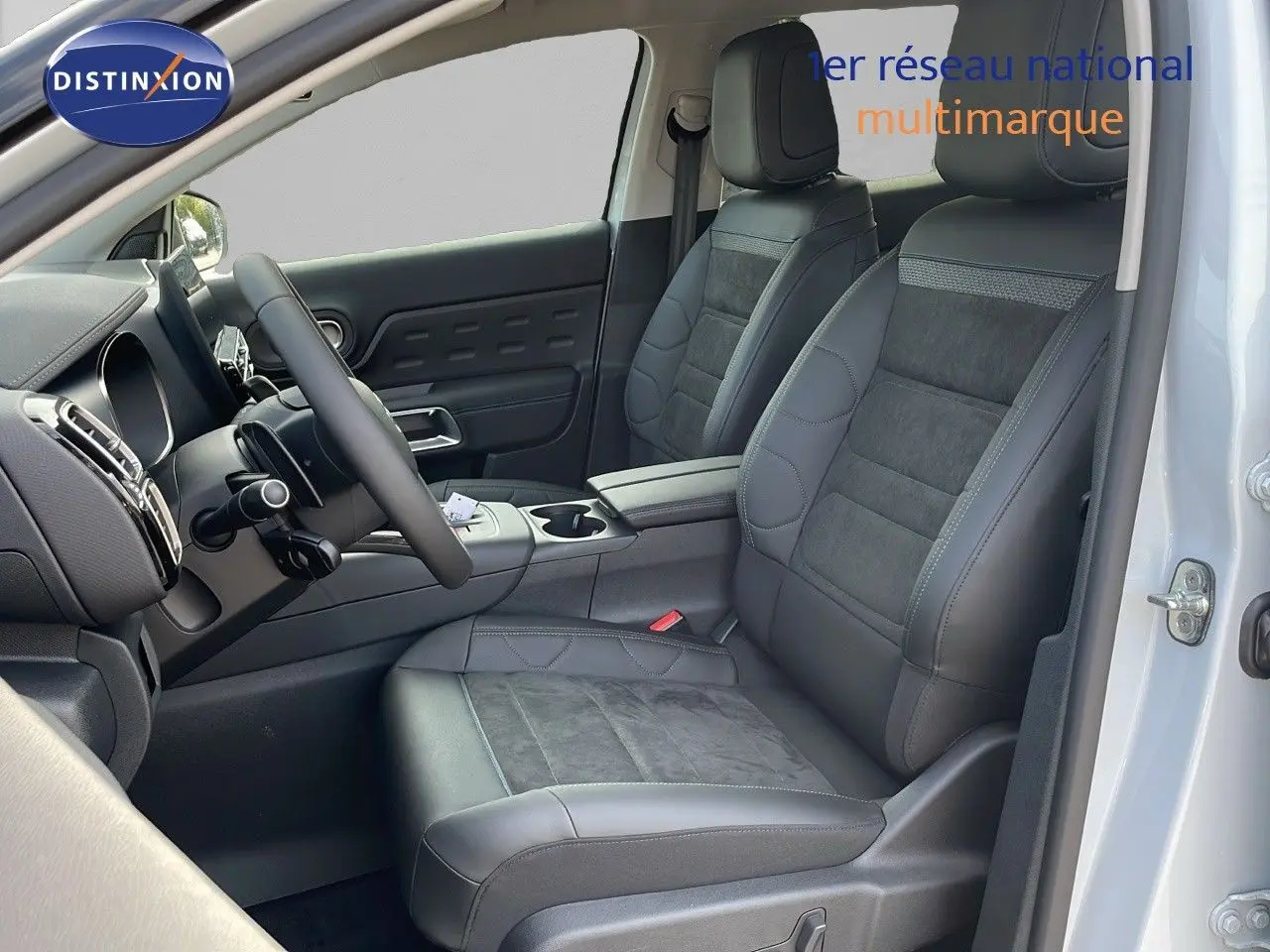 Intérieur avant droit du Citroën C5 Aircross blanc Okenite, sièges cuir noir et alcantara, volant multifonction visible.