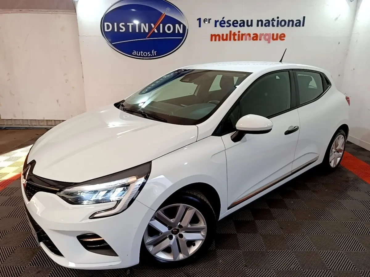 Renault Clio Business blanche vue 3/4 avant droit, avec phares LED allumés et jantes alliage visibles.