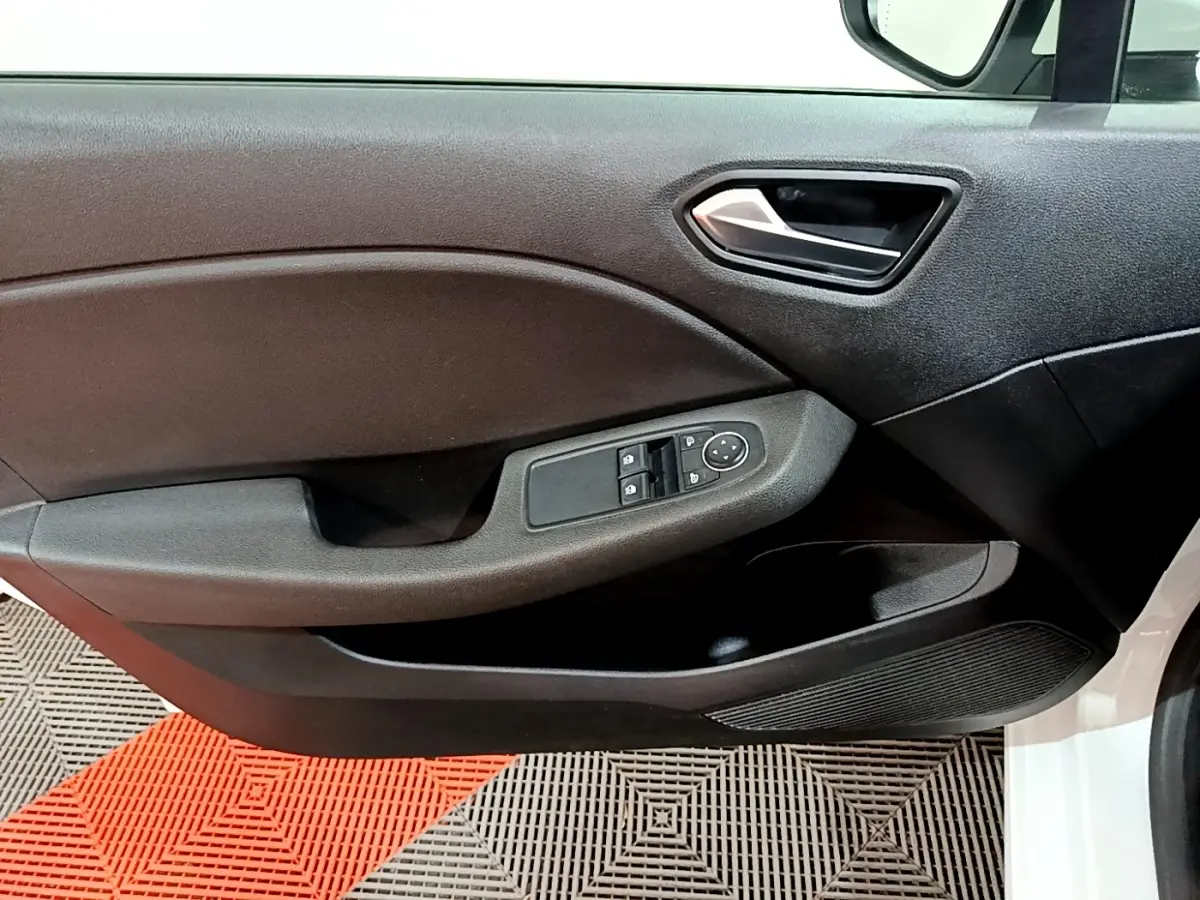 Vue rapprochée de la porte avant gauche d’une Renault Clio Business blanche, avec commandes électriques des vitres et rétroviseurs.