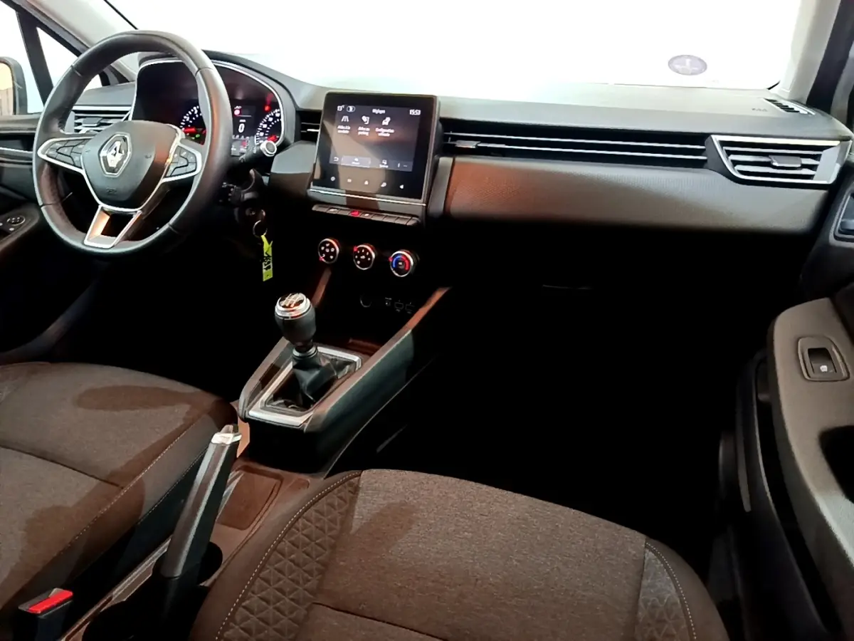 Intérieur avant de la Renault Clio Business 2021, vue côté conducteur, tableau de bord noir avec écran tactile et levier de vitesse manuel.