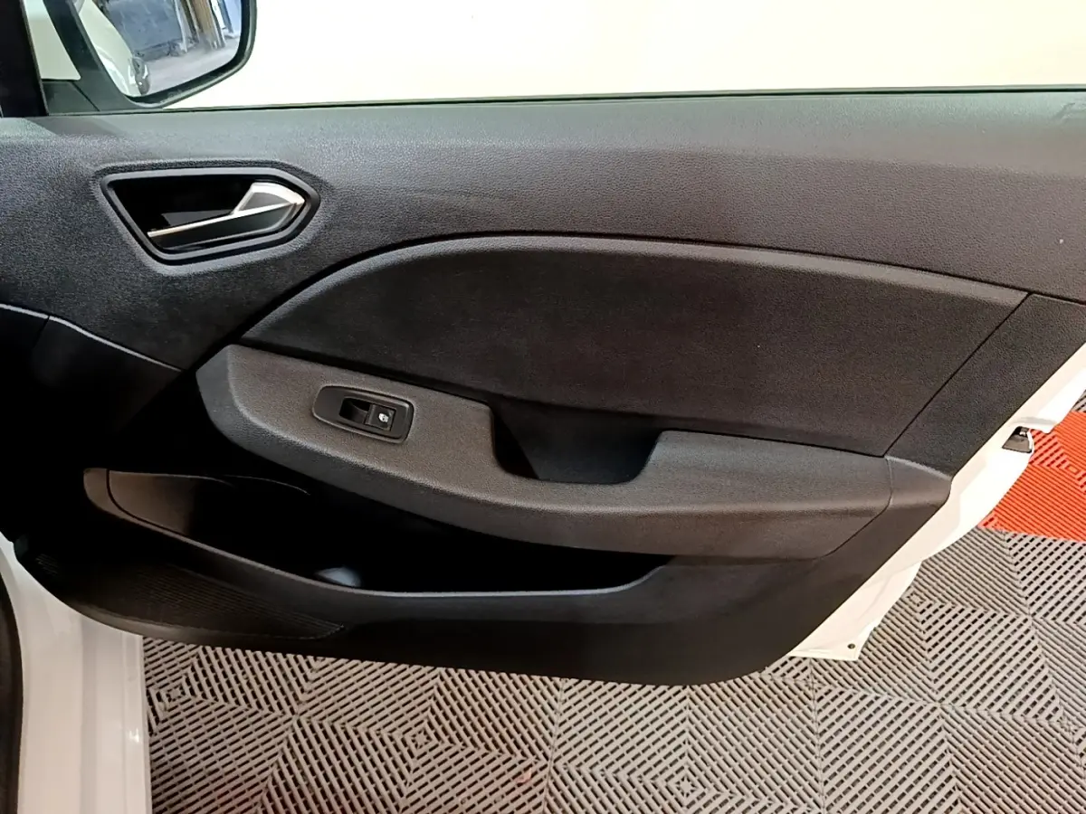 Vue rapprochée de la porte avant gauche noire intérieure d’une Renault Clio Business blanche, avec commande de vitre électrique.