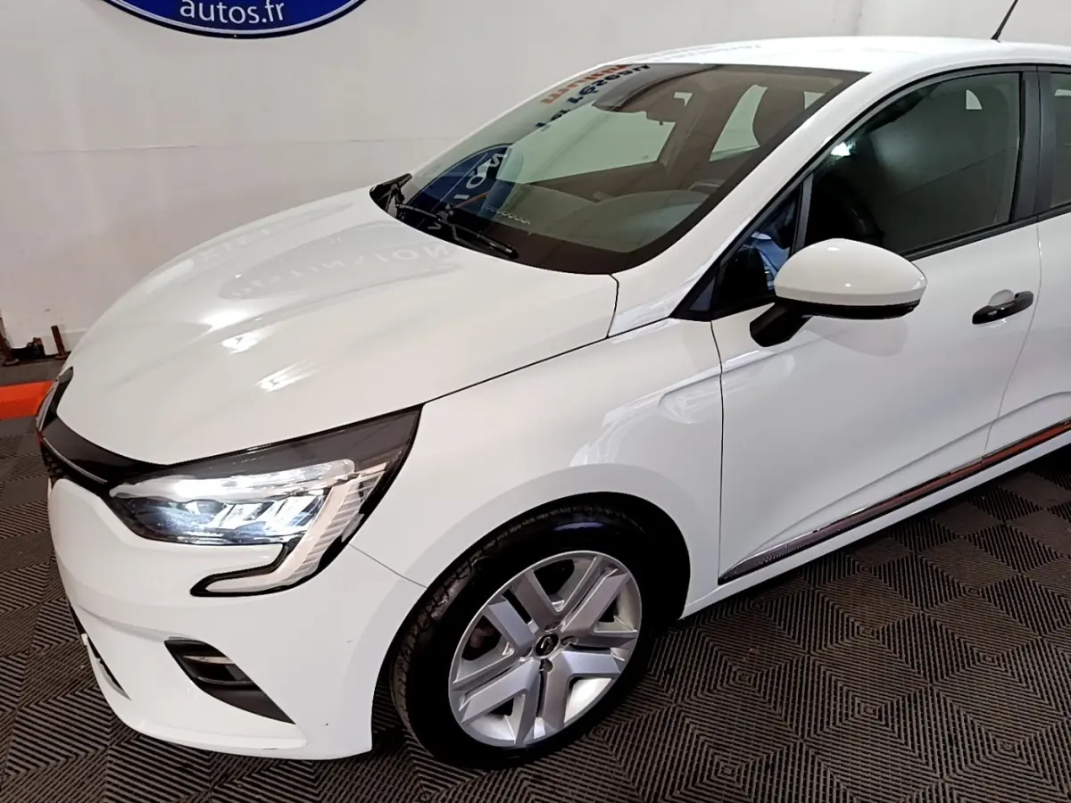 Renault Clio Business blanc vue 3/4 avant droit, avec phares LED allumés et jantes alliage visibles.