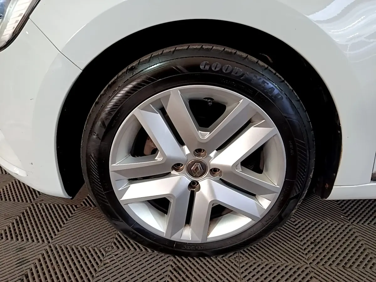 Gros plan sur la roue avant droite d’une Renault Clio blanche avec jante alliage et pneu Goodyear.