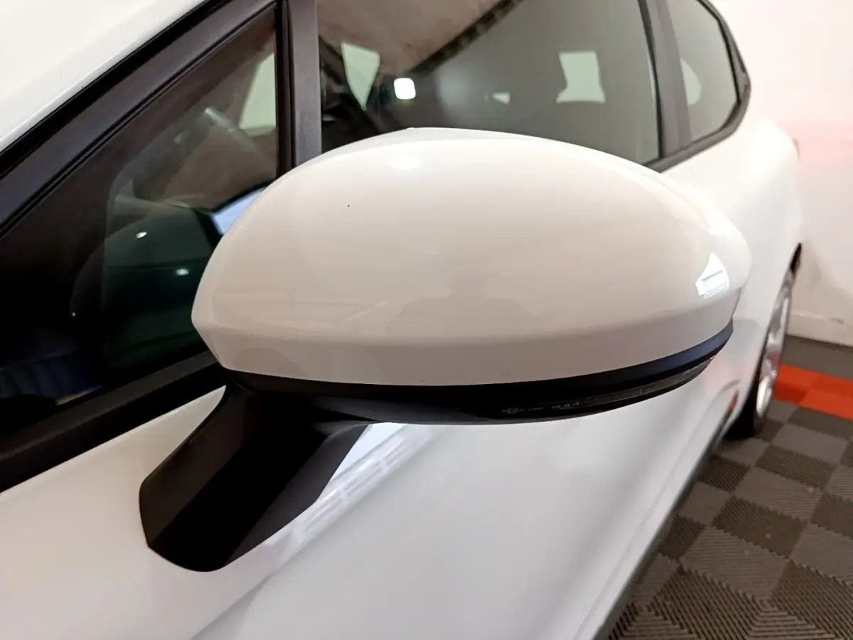 Rétroviseur droit blanc en gros plan sur Renault Clio Business 2021, vue latérale avec carrosserie blanche visible.