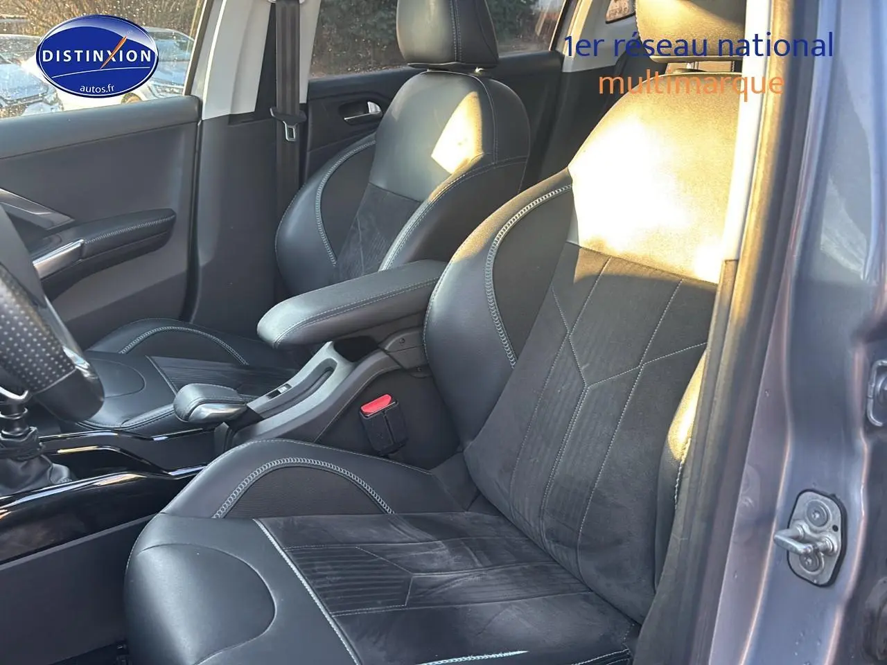 Vue intérieure côté conducteur de la Peugeot 2008 gris clair, sièges en cuir et alcantara noirs avec surpiqûres contrastantes.