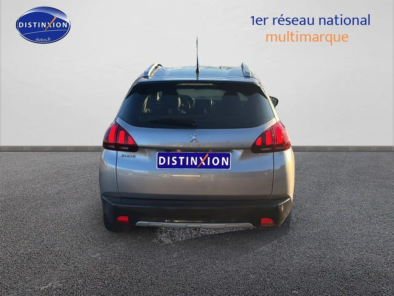 Vue arrière d'un Peugeot 2008 gris clair avec feux LED et barres de toit visibles sur fond neutre.