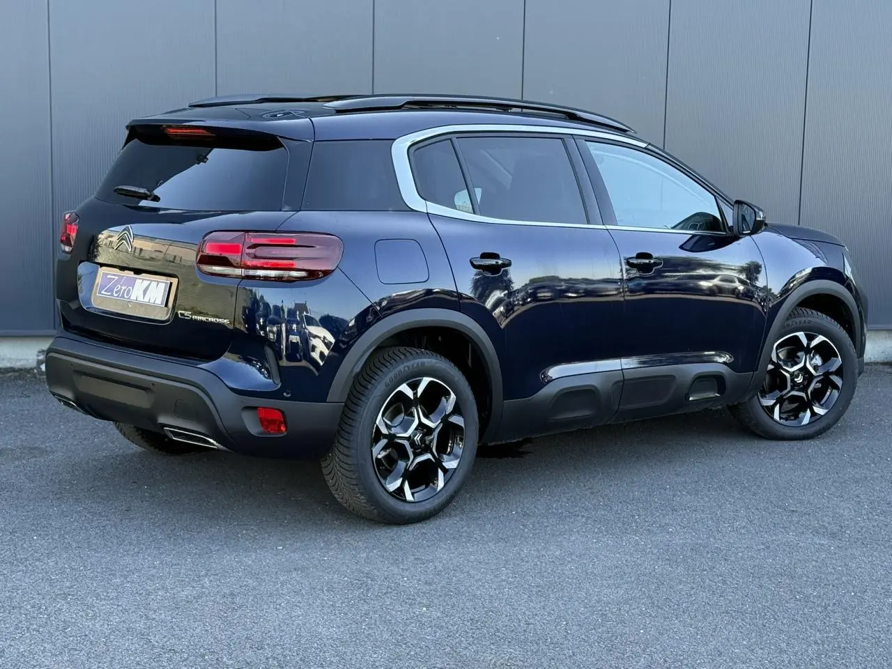 Vue 3/4 arrière droite d'un Citroën C5 Aircross Bleu Eclipse avec jantes alliage bi-ton et toit panoramique noir.