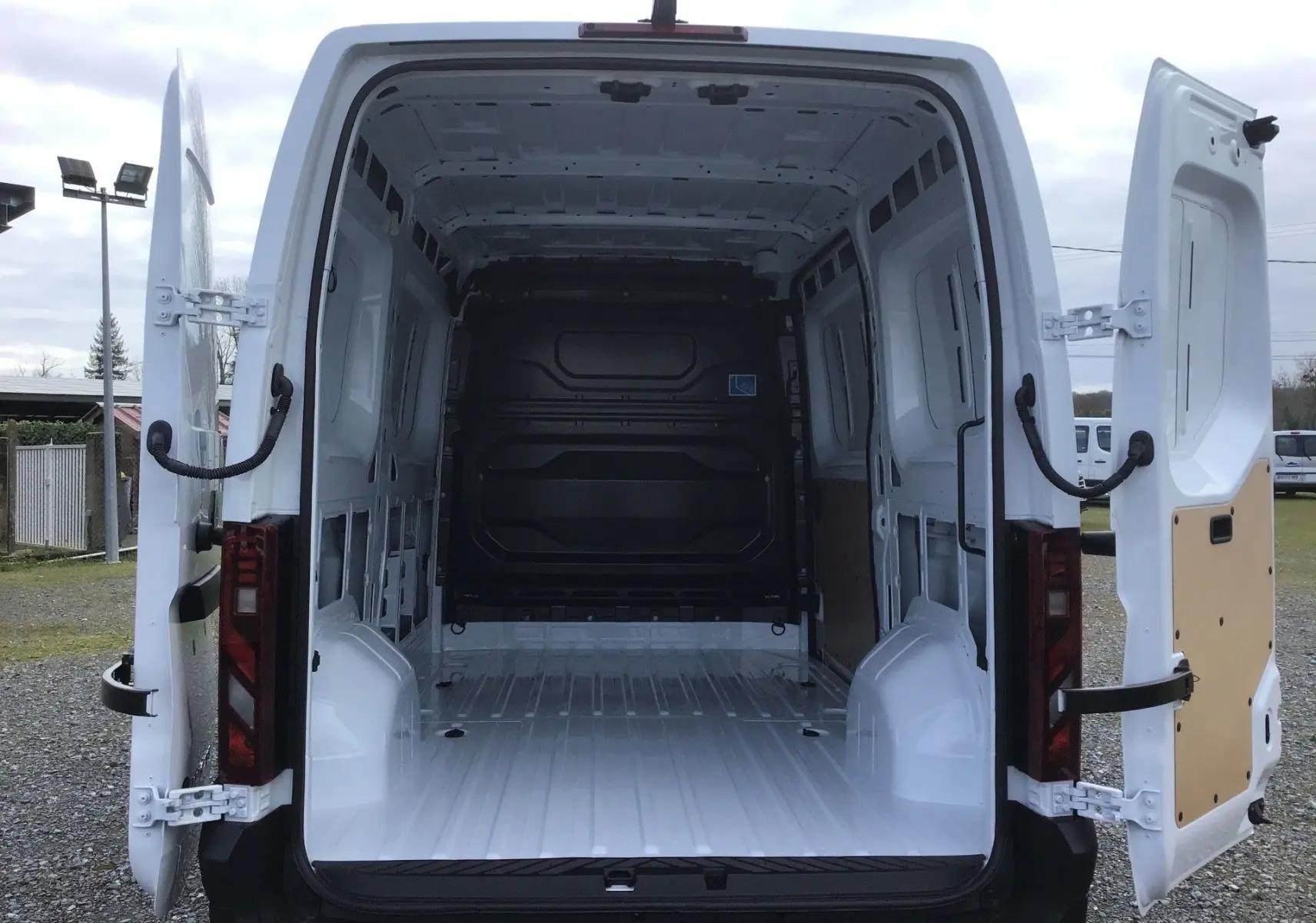 Vue arrière d’un Renault Master blanc 2026 avec portes arrière ouvertes montrant la grande zone de chargement vide.