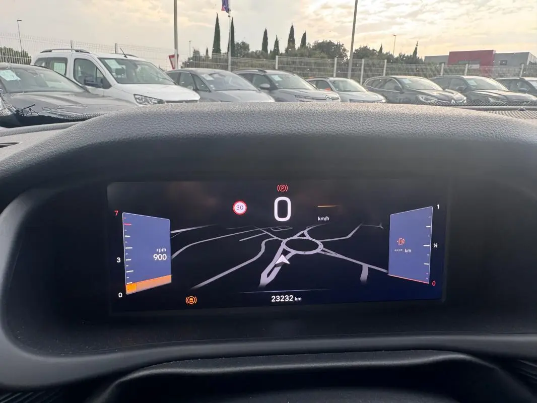 Vue intérieure du tableau de bord numérique du Jeep Avenger blanc, affichant la vitesse à 0 km/h et un compteur de 23 232 km.