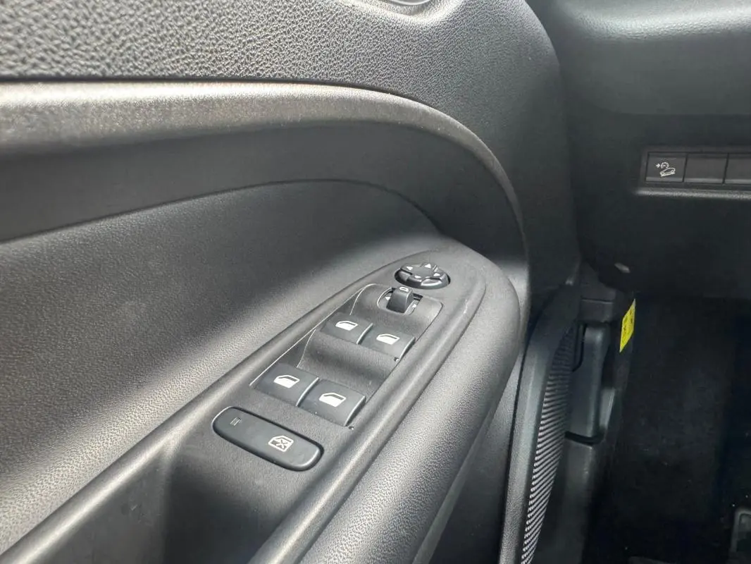 Gros plan sur le panneau de commandes des vitres électriques côté gauche intérieur du Jeep Avenger blanc 2025.