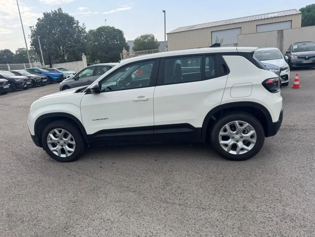 Jeep Avenger blanc en vue profil côté gauche, avec jantes alliage 17 pouces et toit noir contrasté.