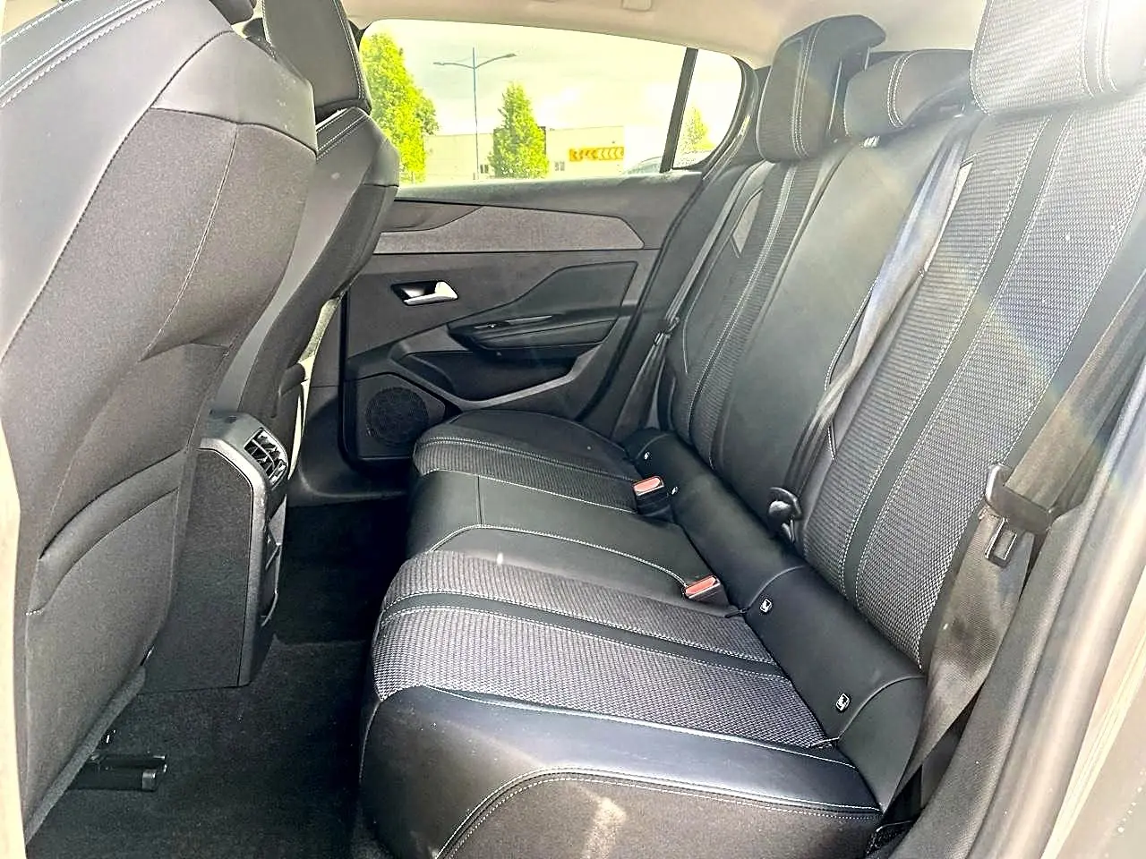 Vue latérale droite de la banquette arrière noire de la Peugeot 308 2025, avec appuie-têtes et ceintures visibles.
