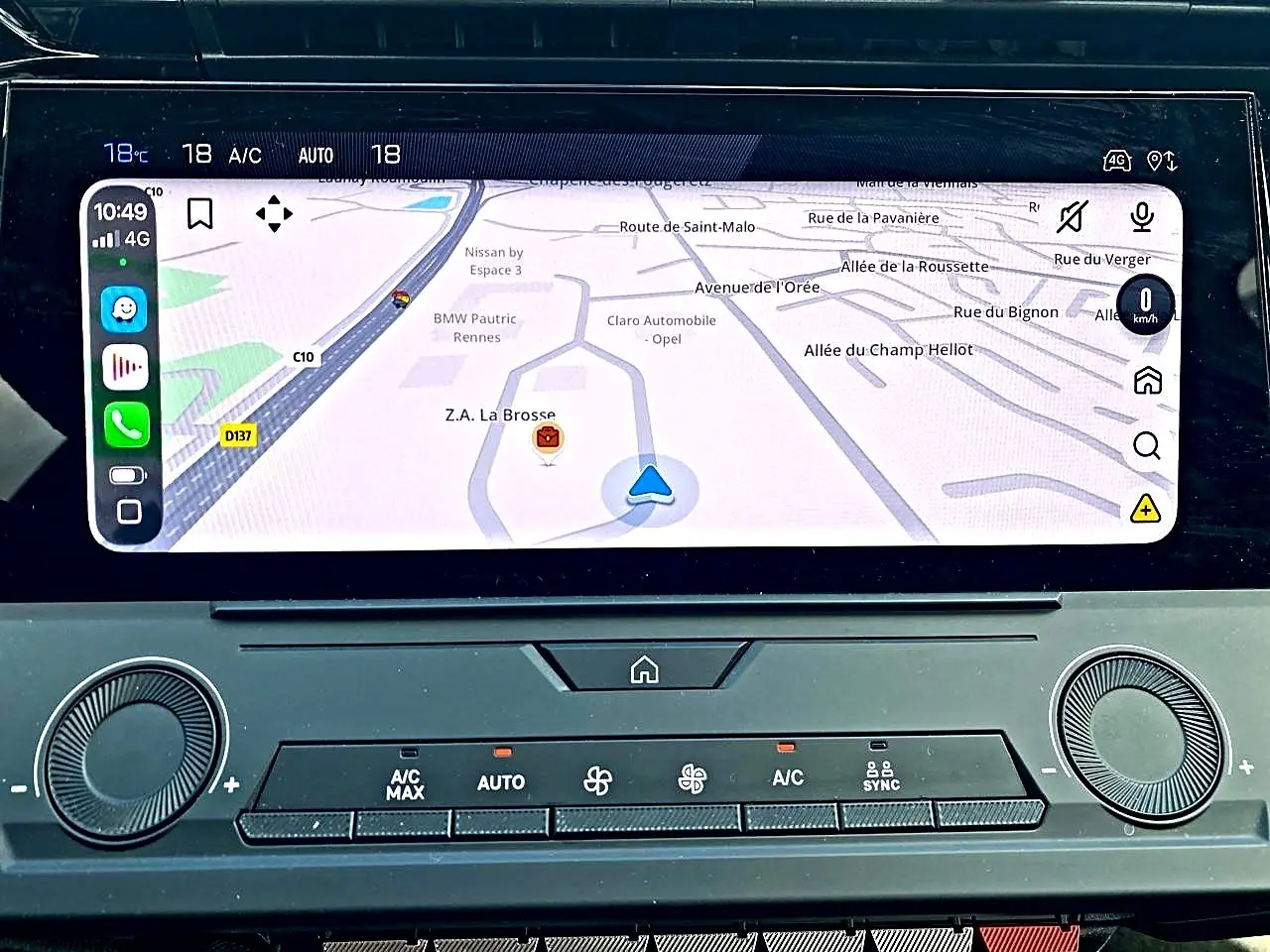 Vue rapprochée de l’écran tactile central du Peugeot 308 gris 2025 affichant la navigation GPS et la climatisation automatique.