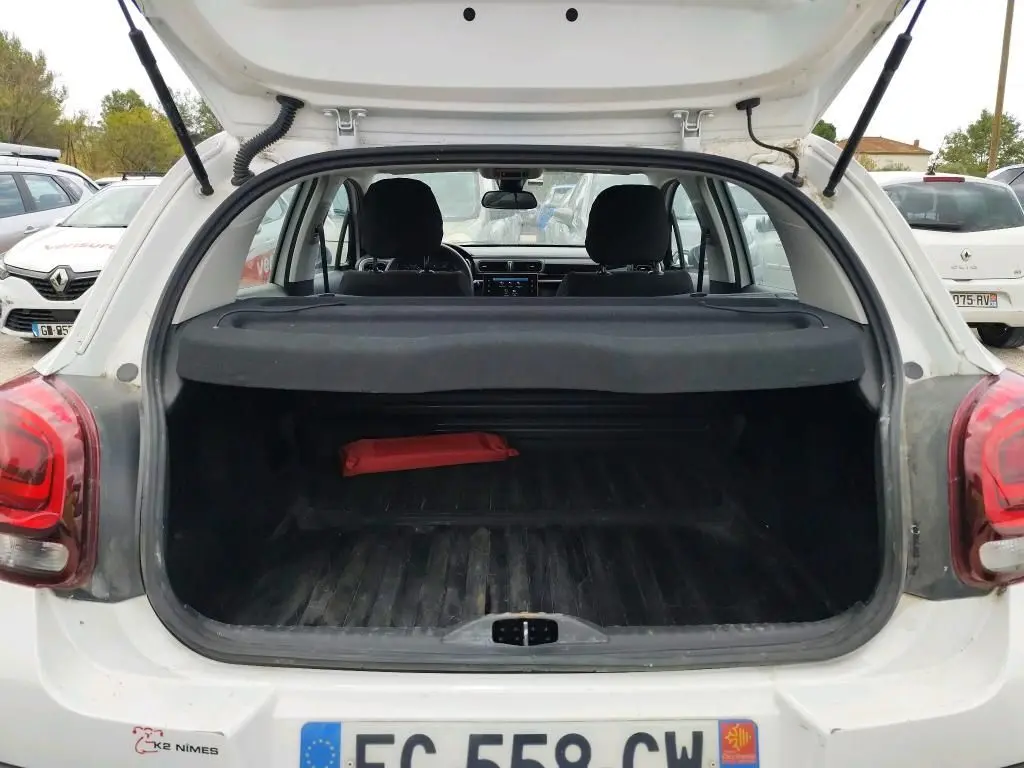 Coffre ouvert vu de l'arrière d'une Citroën C3 Société blanche, montrant l'espace de chargement et l'intérieur.